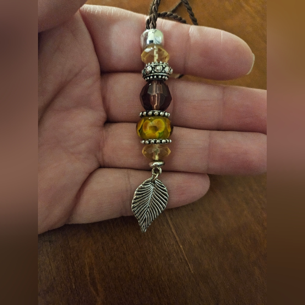 Silver tone leaf and flower charm necklace